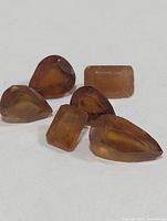 Six loose hessonite garnets, pear and rectangular cuts