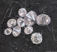 Eight small round pink diamonds on black background