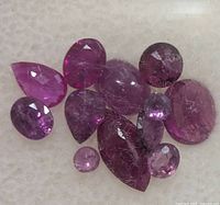 Group of 11 faceted ruby gemstones showing various cuts and colour