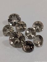 Front view of all eight smoky quartz gemstones showing size and color