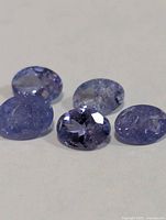 Five loose tanzanite gemstones close-up