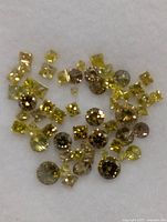 Loose yellow diamonds spread on white background
