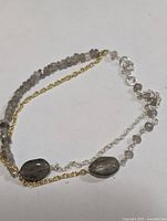 Full view of multi-strand silver and gold-tone bracelet with labradorite beads and lobster clasp