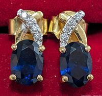 Close-up of both earrings showing blue stones, clear accents, metal colour and backing