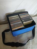 Blue carrying case open showing two rows of CDs
