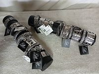 Two display rolls holding twenty silver-tone ornate bracelets with Gift Gallery tags