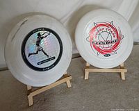 Both white 175g Frisbee discs on stands front view
