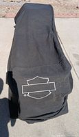Cover draped over object, logo visible, shows size and overall condition