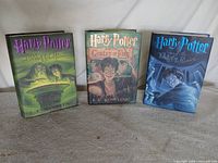 All three Harry Potter hardcovers standing with dust jackets visible
