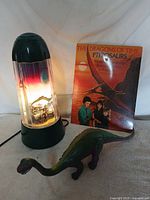 All three items grouped: night light illuminated, book, Brontosaurus figure