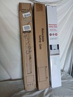 Three boxed retractable gates upright against backdrop