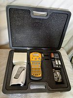 Open case showing label maker, manual, cartridges, accessory bag