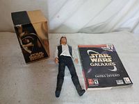 All three items grouped: VHS box set, action figure, PC game manual