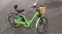 Left side view of bright green Daymak Paris V5 e-bike showing frame, battery, rear hub motor, basket, rack and backrest