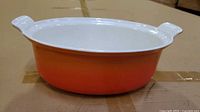 Top view of orange Le Creuset round casserole showing white interior