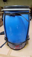 Front view of blue waterproof barrel with harness and straps