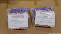 Two sealed quilt kits with visible floral fabrics and certificates