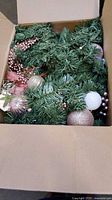 Garland inside shipping carton showing green foliage and ornaments