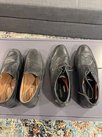 Both pairs of shoes side by side on table