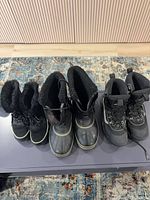 Front view of all three boot pairs showing style and condition