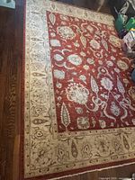 Full view of rug showing red field and ivory border