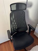 Front angled view showing full chair with mesh headrest, armrests, seat, and base