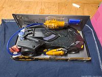 Front angled view of boxed Batmobile showing vehicle and accessories