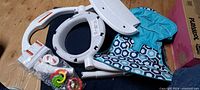 All disassembled seat parts including frame sections, fabric seat, toys
