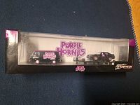Front of sealed Purple Hornies vehicle set box showing van, trailer, car