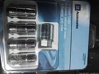 Front of sealed GM Accessories wheel lock kit showing four chrome wheel locks and key