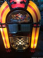 Front illuminated view of Nexxtech CD jukebox showing lights and grille