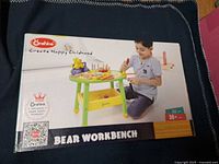 Front of sealed box showing Onshine Bear Workbench set and child using assembled bench