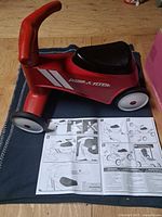 Full view of Radio Flyer ride-on toy with instruction manual