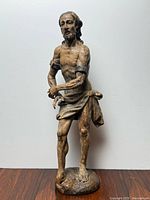 Full front view of the carved polychrome wood statue of Jesus Christ standing on integral base