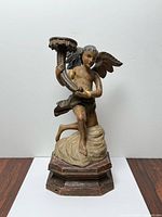 Front view showing angel pose, candle cup, and base