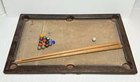 Full view of tabletop pool table with cues and balls