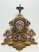 Front view of P.H. Mourey brass and spelter mantle clock with porcelain panels
