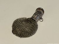 Full view of sterling mesh coin purse lying flat