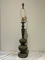 Full view of verdigris metal lamp showing overall form and height