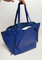 Front/side view of royal blue Celine Cabas Phantom tote showing overall shape, side ties, handles