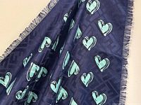 Full view of shawl showing navy base, turquoise hearts, fringe