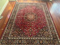 Full view of Persian carpet showing size, medallion and border design