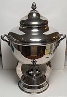 Front view of silver plated samovar with lid, handles, spigot and pedestal base