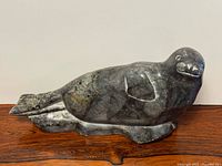 Full view of reclining soapstone seal sculpture