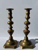 Full view of both brass candlesticks standing upright