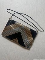 front view of tri-tone metal mesh clutch with strap