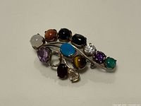 Front view of sterling silver brooch with multi-colored stones