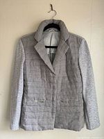 Full front view of grey linen blend down jacket on hanger