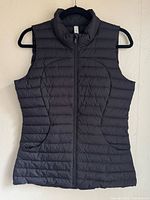 Front view of black down vest on hanger