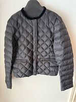 Full front view of black quilted jacket on mannequin